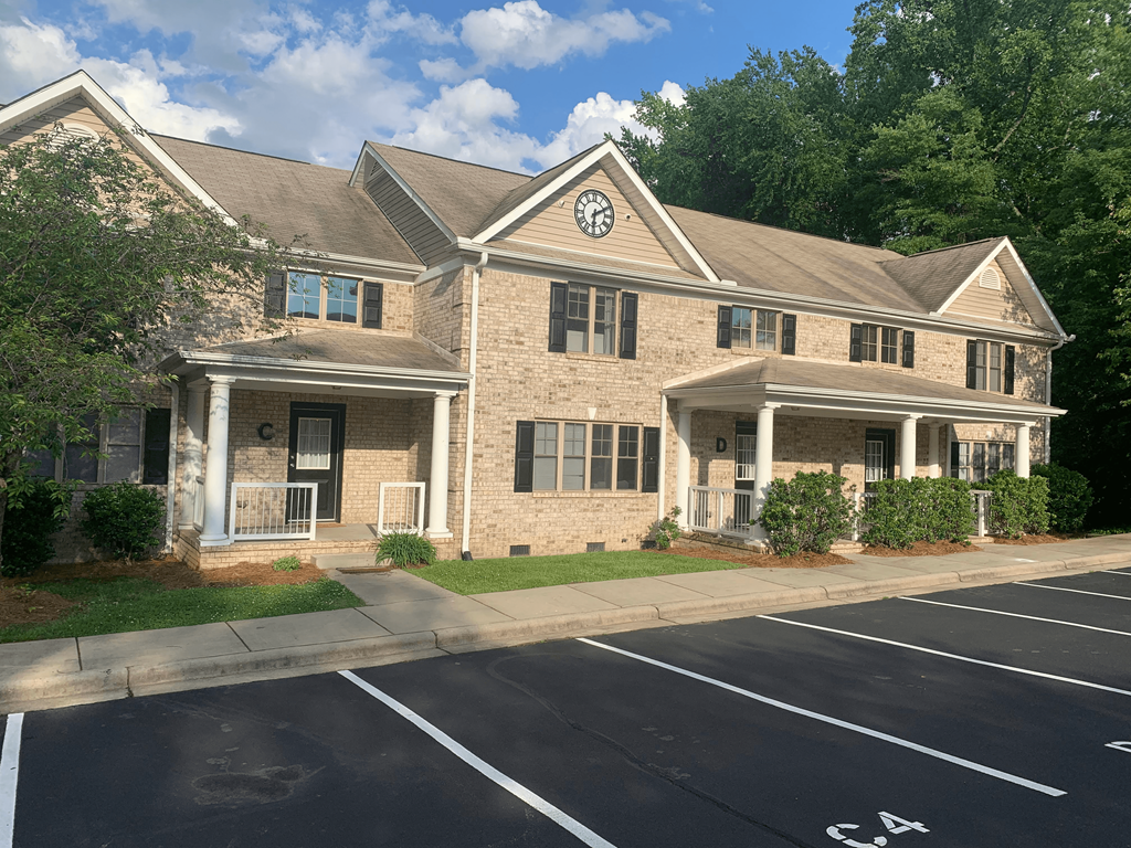 a brick house with a driveway and a parking lot