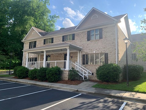 the front of a brick house with a porch and stairs