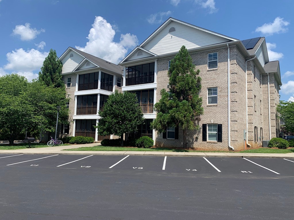 an apartment building with a parking lot in front of it