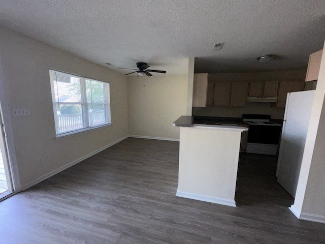 an empty living room with a ceiling fan
