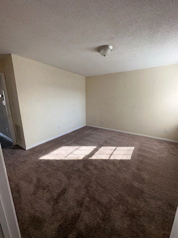 an empty room with brown carpet and a door