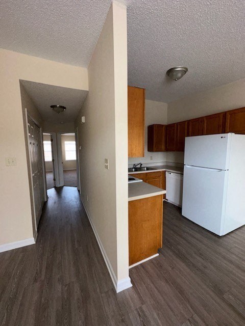 an empty kitchen with wood floors and white cabinets
