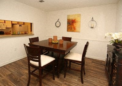A dining room with a wooden table and chairs.