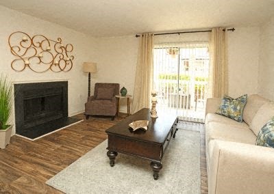 A living room with a fireplace, a chair, a couch, and a coffee table.
