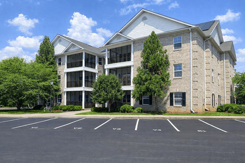 A large building with a parking lot in front.