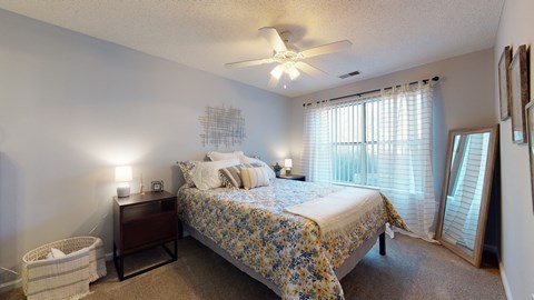 a bedroom with a bed and a ceiling fan