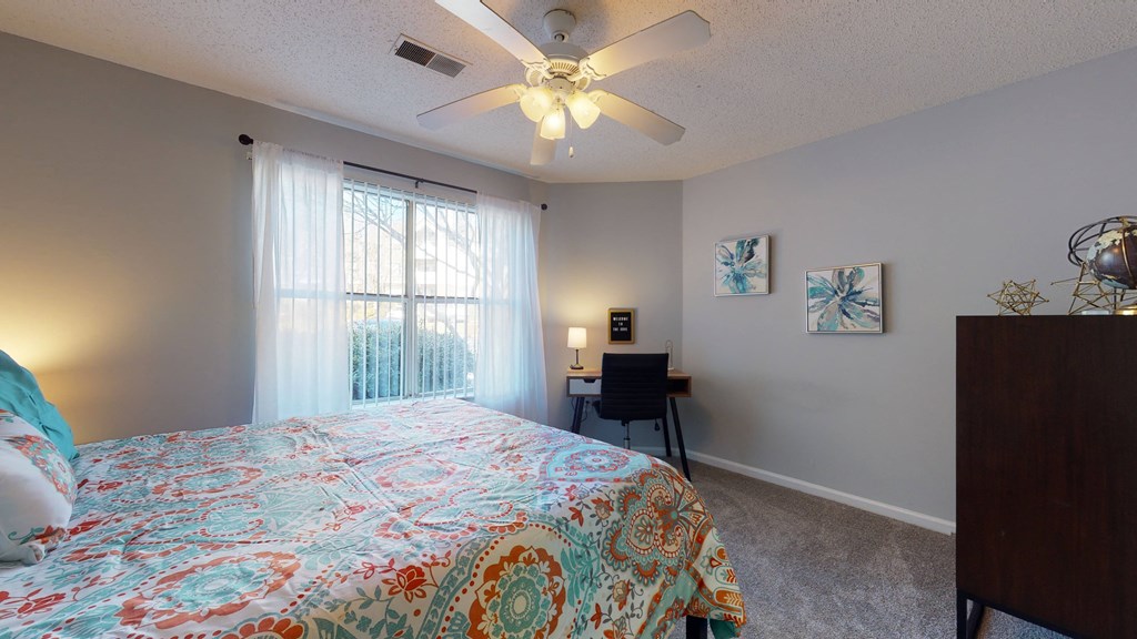 a bedroom with a large bed and a ceiling fan