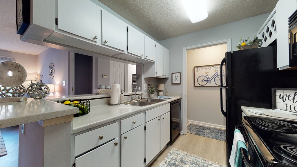 a kitchen with white cabinets and a sink and a refrigerator