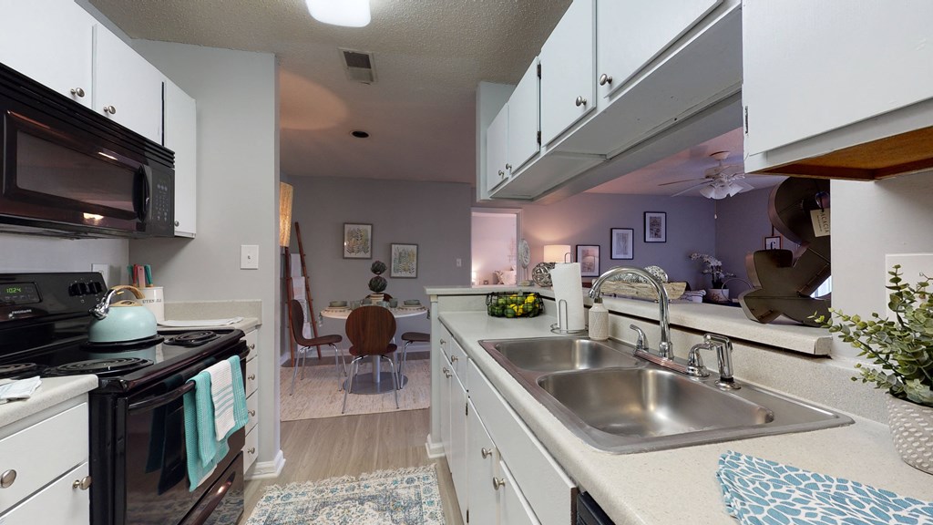 an open kitchen and living room with a stainless steel sink