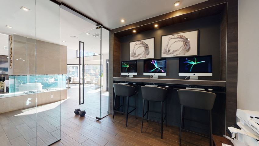 a bar with three monitors in a room with a glass door