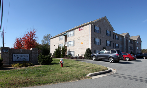 a brick apartment building with a parking lot and a fire hydrant