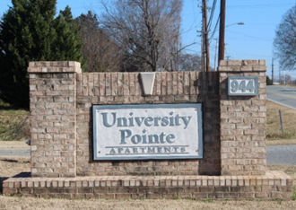 the sign for the university pointe apartments on the side of the road