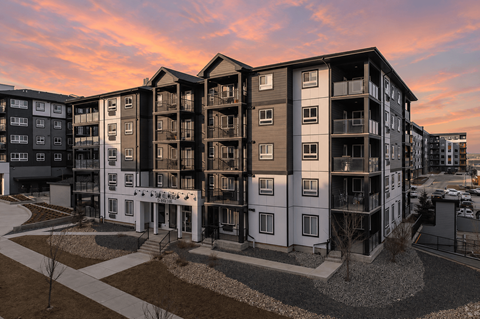 A modern apartment complex with a mix of white and dark exterior walls.
