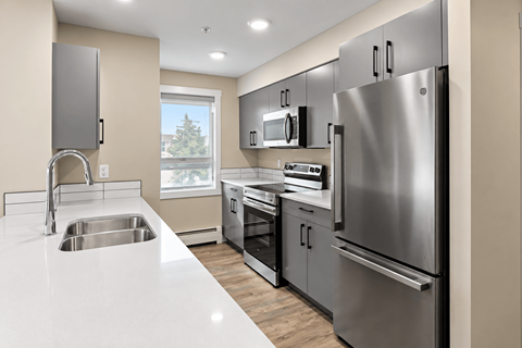 A modern kitchen with stainless steel appliances and a white countertop.