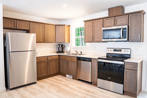 A kitchen with wooden cabinets and stainless steel appliances.