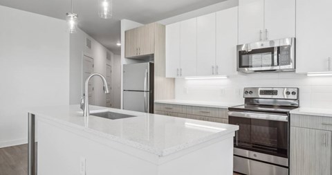 A modern kitchen with white cabinets and stainless steel appliances.