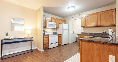 A kitchen with wooden cabinets and a black counter.