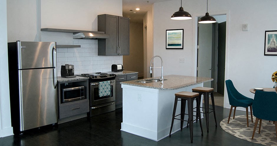 a kitchen with a center island and a stainless steel refrigerator