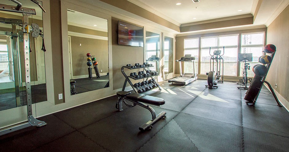 a home gym with exercise equipment and a tv