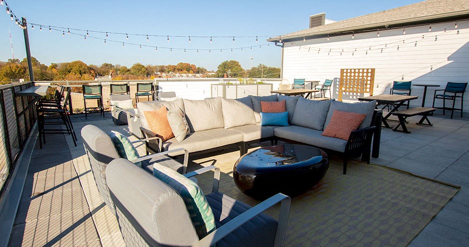 a patio with couches and tables on a roof