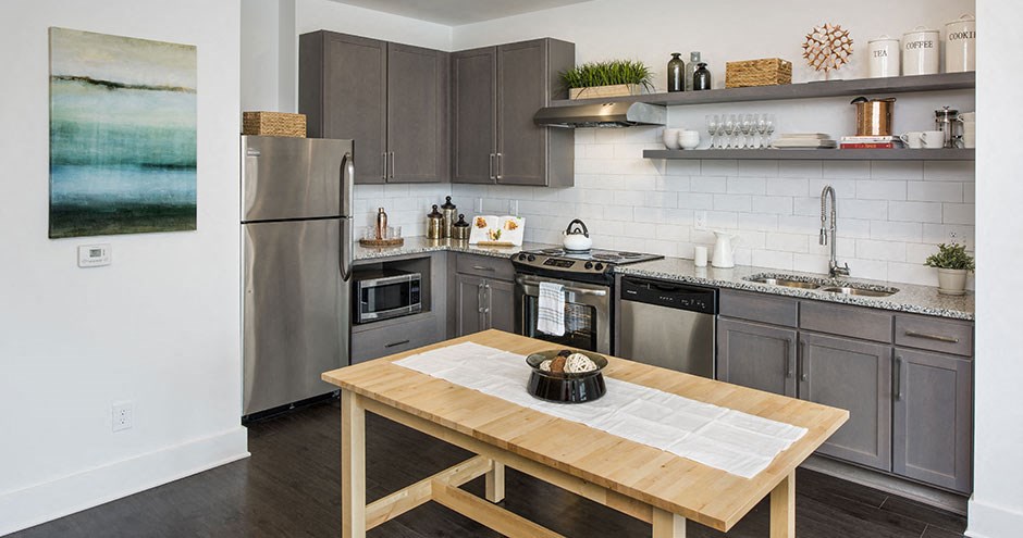 a kitchen with stainless steel appliances and a wooden table