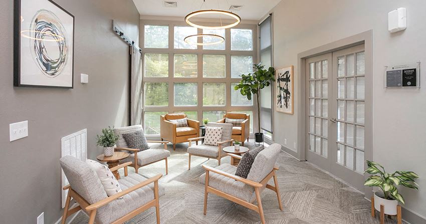 a living room with chairs and a large window