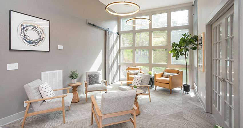 a living room with chairs and a large window