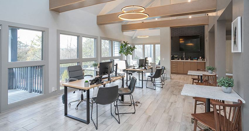 a conference room with tables and chairs and large windows