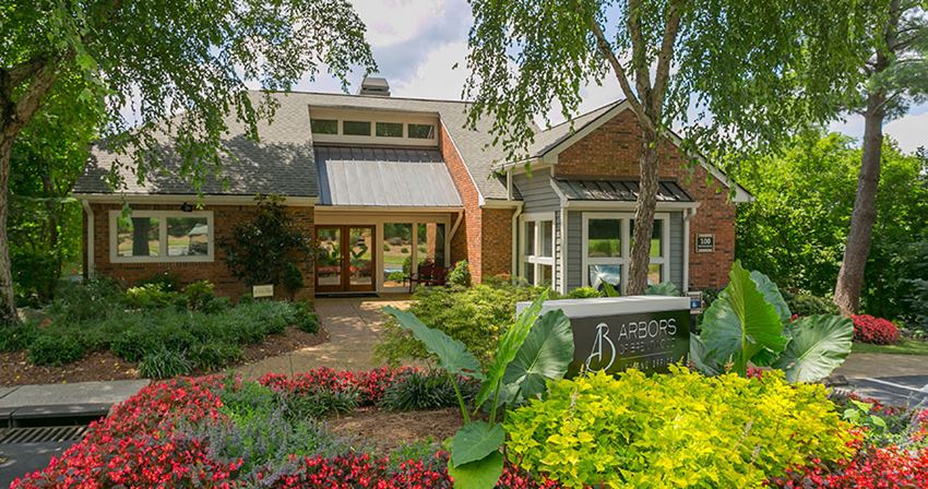 a house with a sign in front of a garden