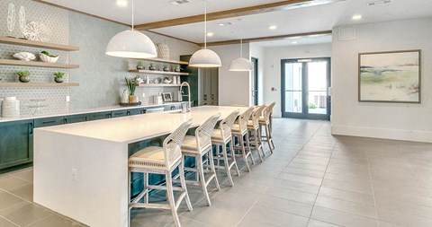 a kitchen with a long counter and chairs