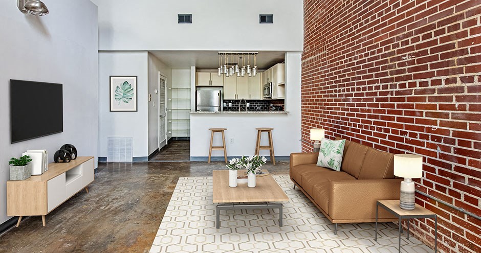 a living room with a couch and a brick wall