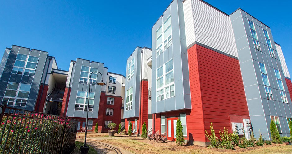a row of new apartment buildings with red and gray roofs