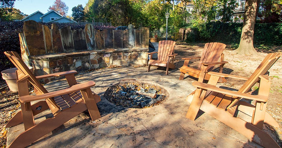 a patio with two wooden chairs and a fire pit