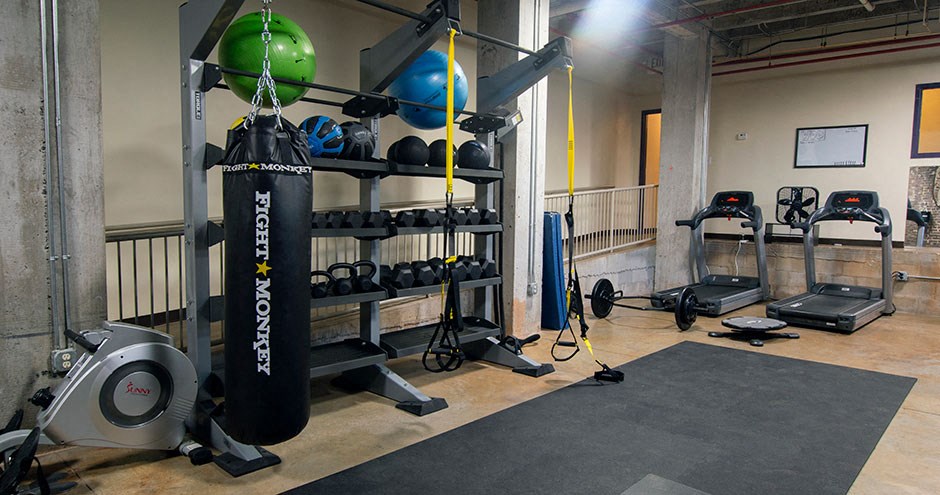 a gym with weights and a punching bag on a rack