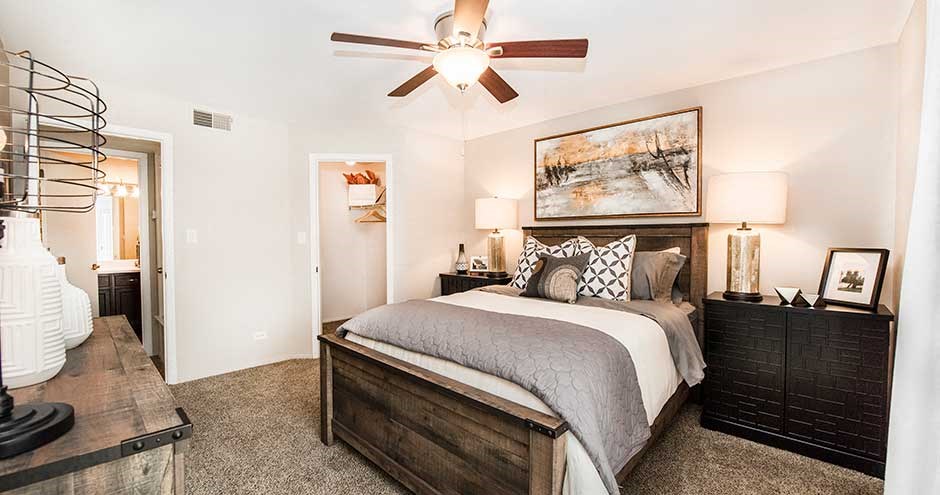 a bedroom with a bed and a ceiling fan