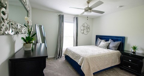 A bedroom with a bed, dresser, and mirror.