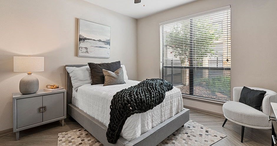 a bedroom with a bed and a large window