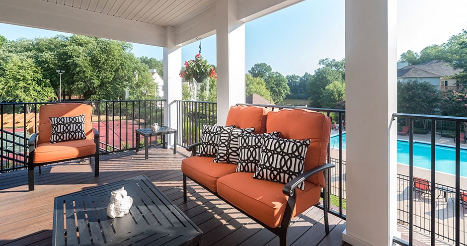 a porch with a pool and chairs and a table