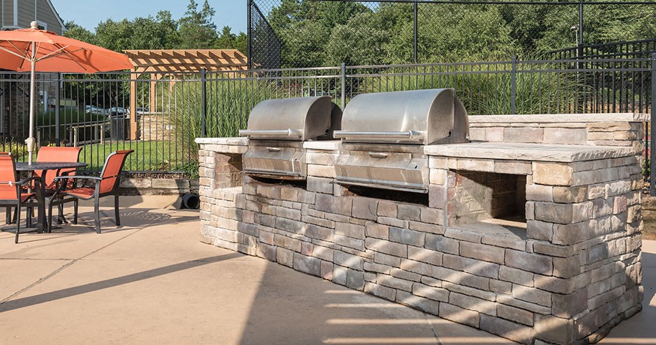 a stone pizza oven in a backyard with tables and chairs