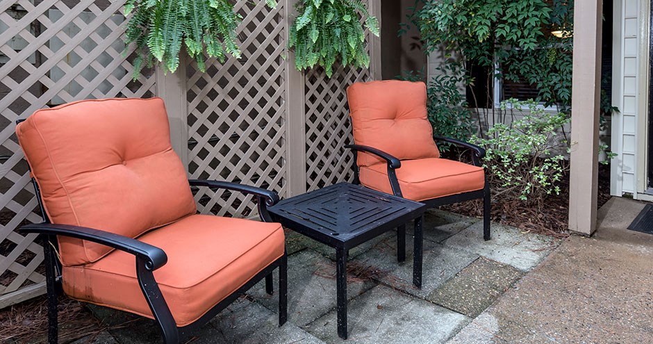 two orange chairs and a table on a patio