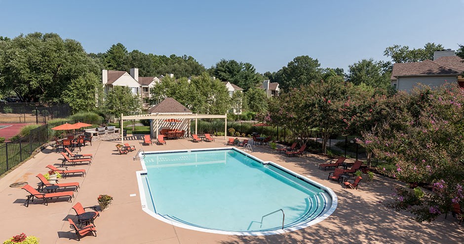 a swimming pool with tables and chairs around it