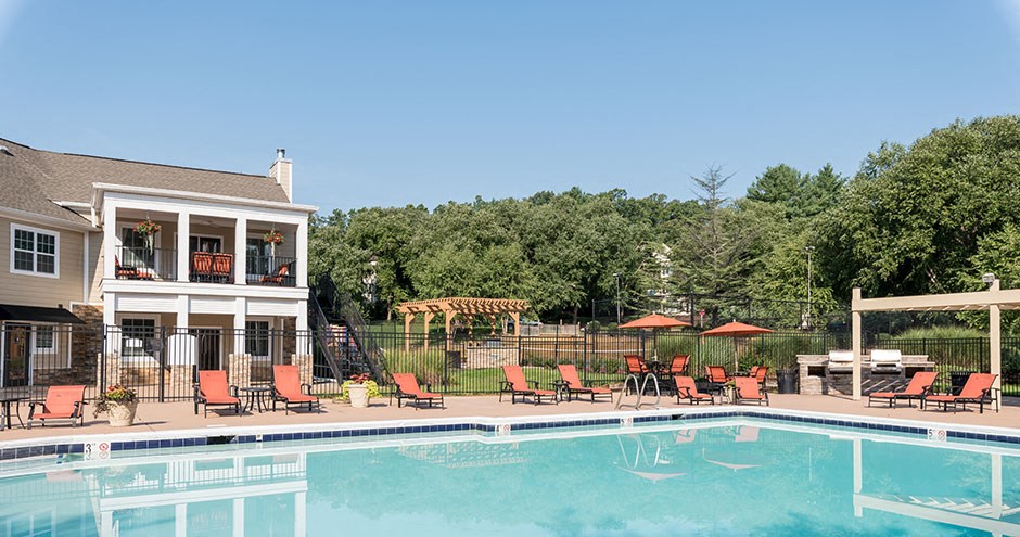 a swimming pool in front of a house with a resort style pool