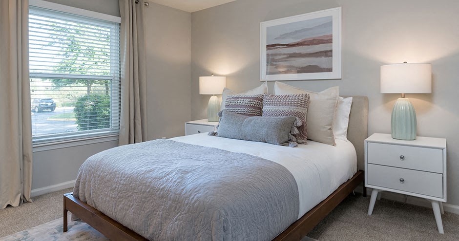 a bedroom with a bed and two lamps and a window