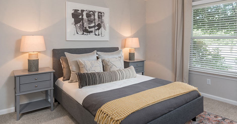 a bedroom with a bed and two lamps and a window