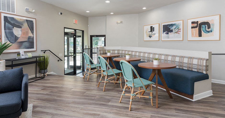 a dining room with tables and chairs and paintings on the wall