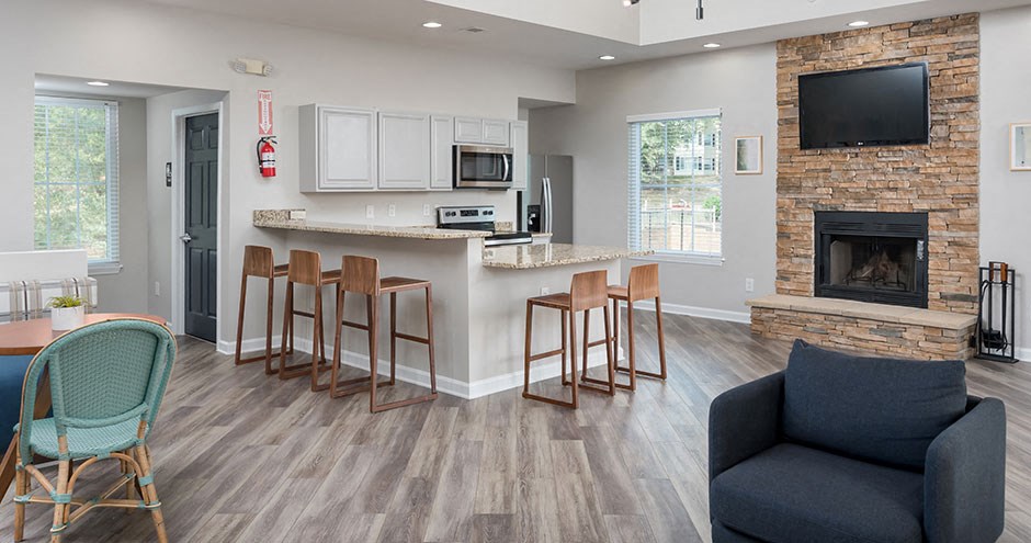 a living room with a fireplace and a bar with chairs