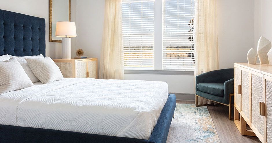 a bedroom with a bed and two windows