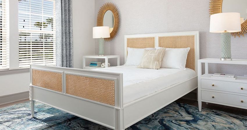 a bedroom with a white bed and a mirror