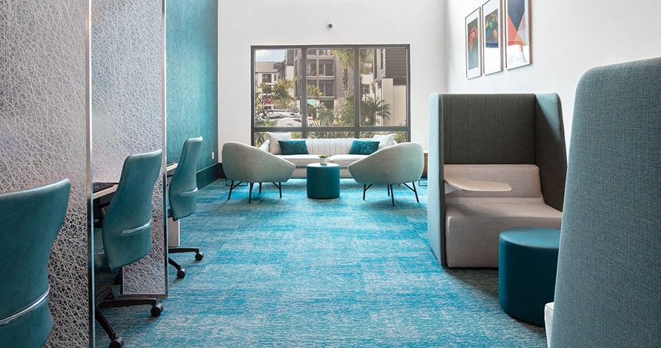 a lounge area with chairs and tables and a window