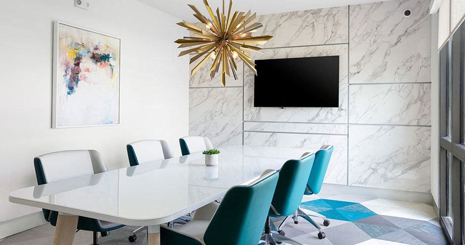a conference room with a white table and chairs and a television